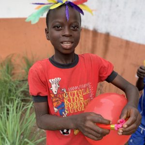 Enfant souriant lors d'une action solidaire de l'association JAIMESUD